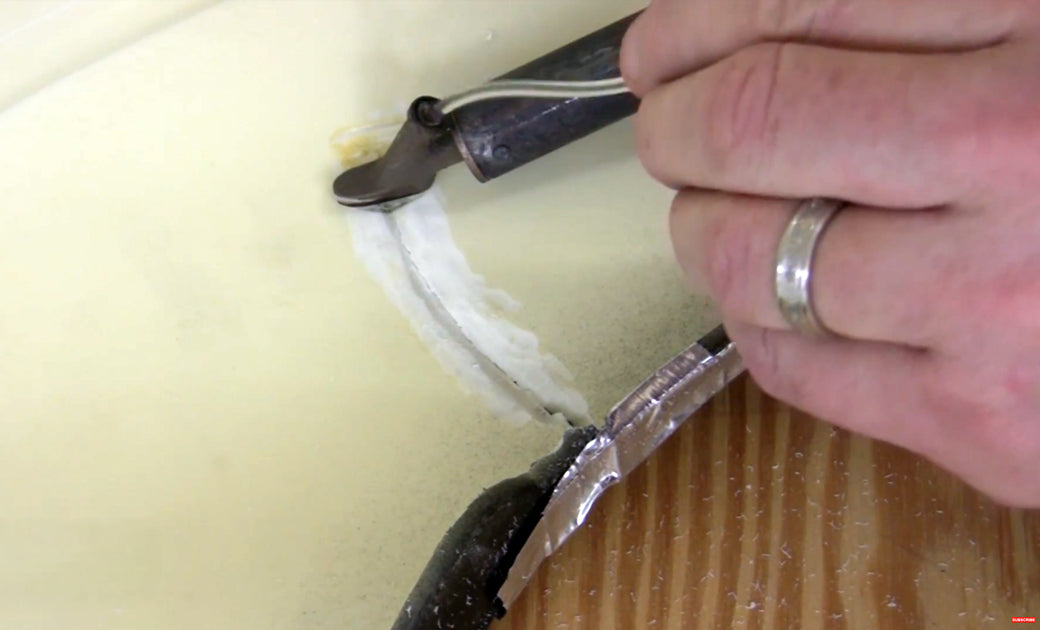 A urethane bumper cover with a crack is being repaired by an airless plastic welder. PUR rod is being fed through the tube in the airless welder tip.