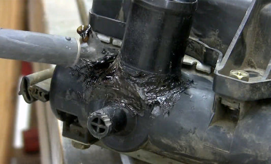 An airless plastic welder smoothing a weld on a radiator