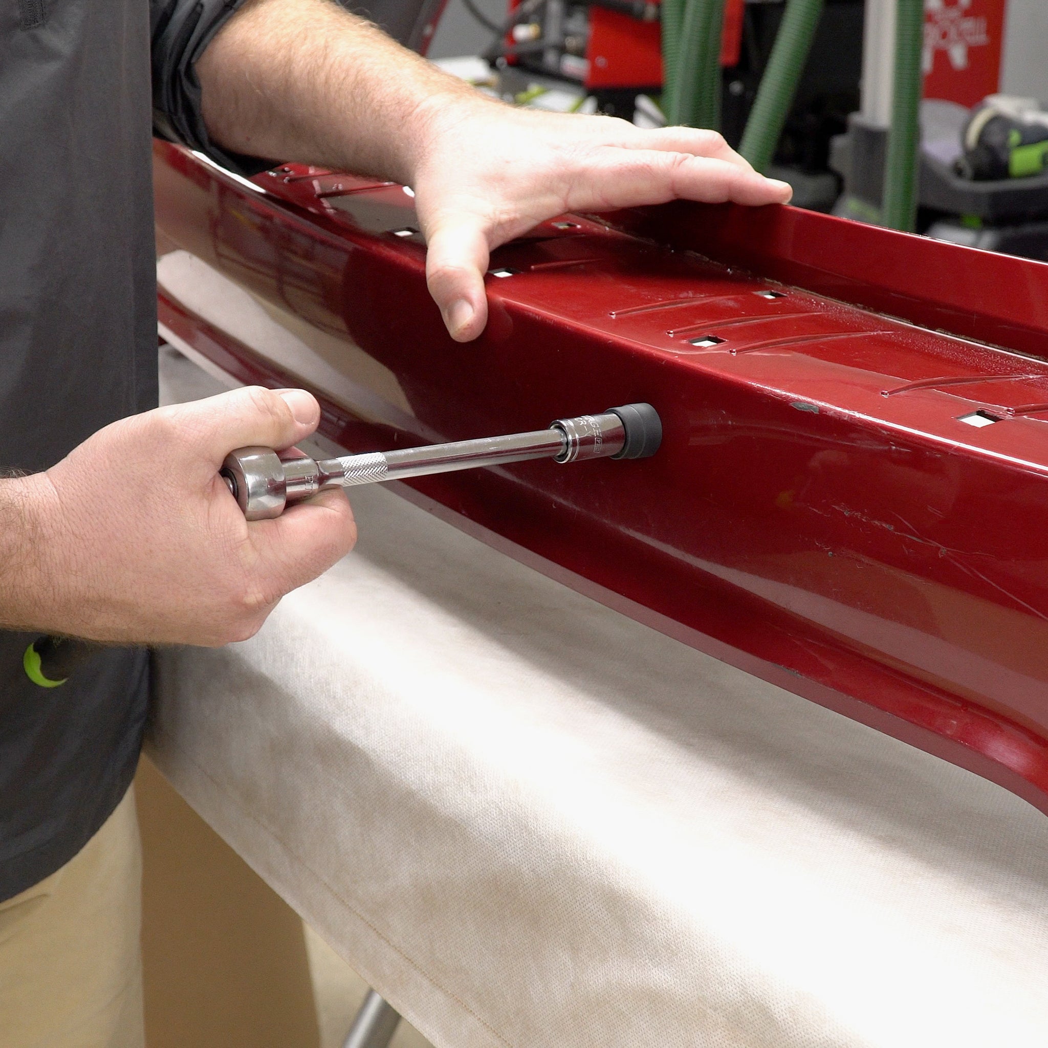 Using the sensor hole cutter to cut through a bumper cover