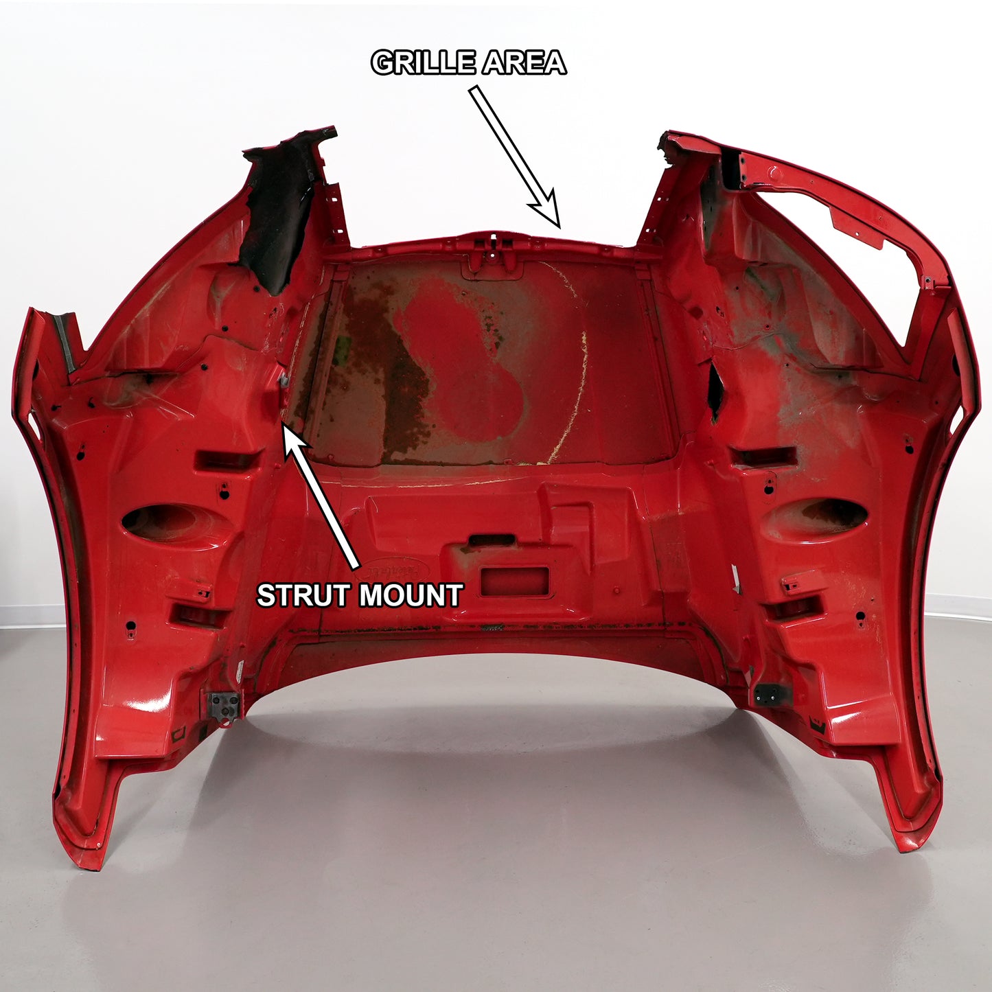 Full view of the hood with the grille area and strut mount labeled