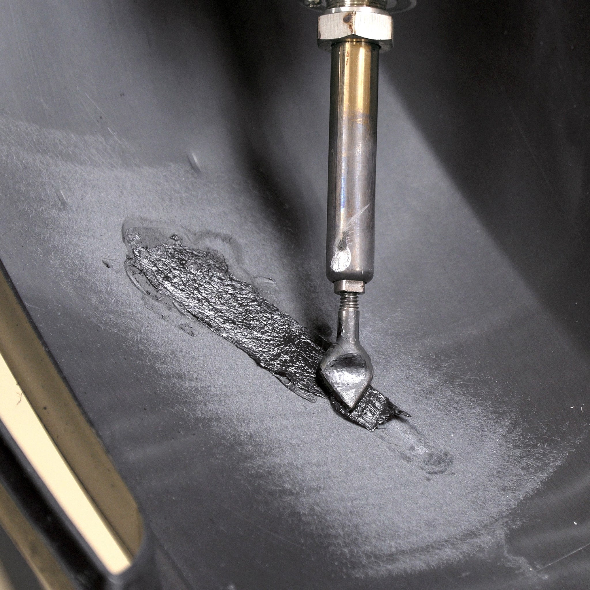 A bumper cover is being repaired with the airless plastic welder and FiberFlex repair rod