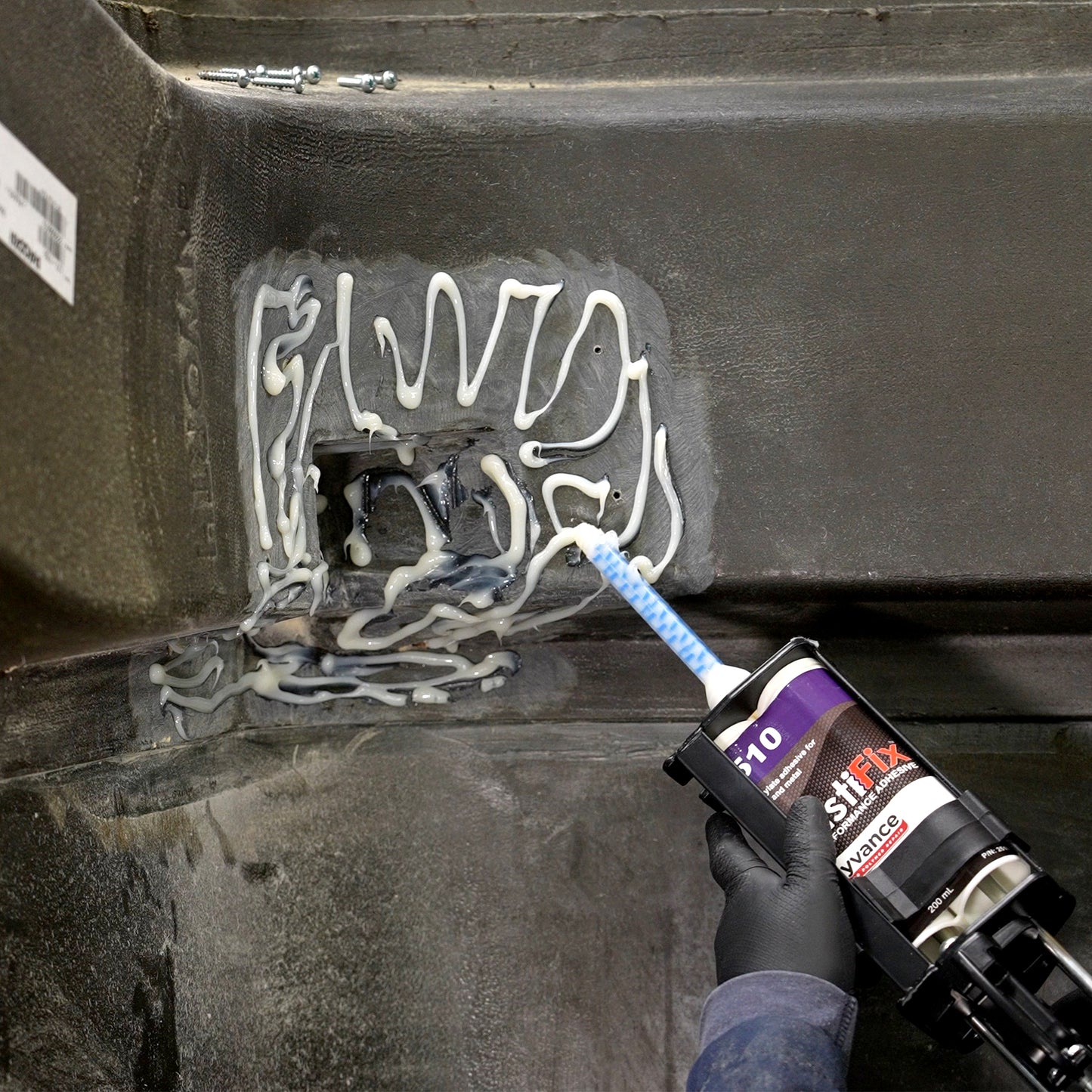 Applying the PlastiFix adhesive to the sanded area of the hood
