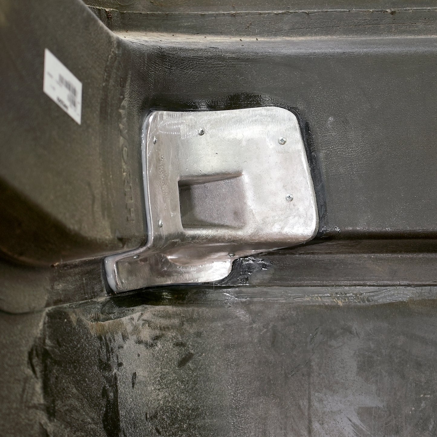 The aluminum casting secured to the hood
