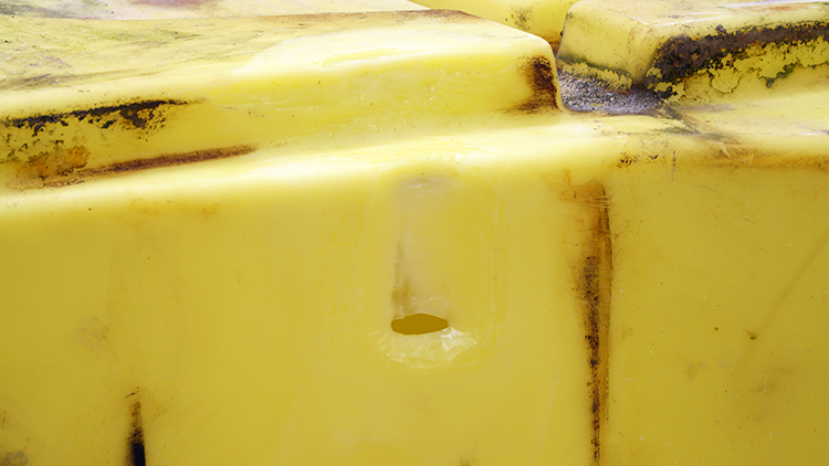 The tank with the melted plastic removed. A crack is now visible where the melted plastic had been.