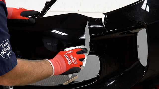 Wiping the bumper cover with plastic cleaner.