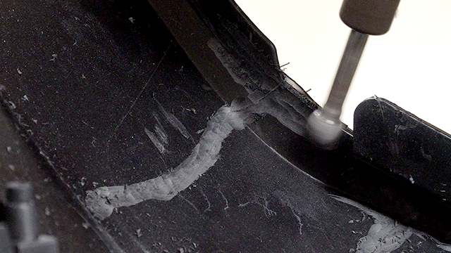 Grinding a v-groove along the edge of the crack