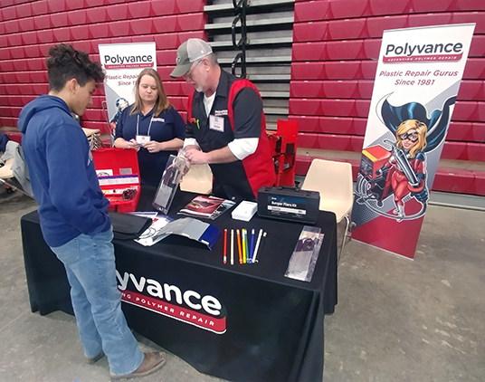 Mark and Alana at the Polyvance booth speaking with a high schooler