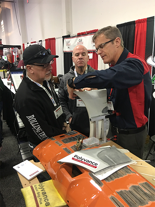 Kurt shows off a completed weld to two interested men.