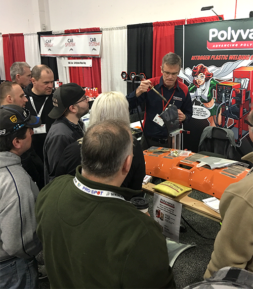 Kurt welding a bumper with the nitrogen plastic welder in front of a crowd