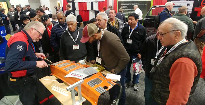 Mike welding a bumper with the nitrogen plastic welder in front of a crowd