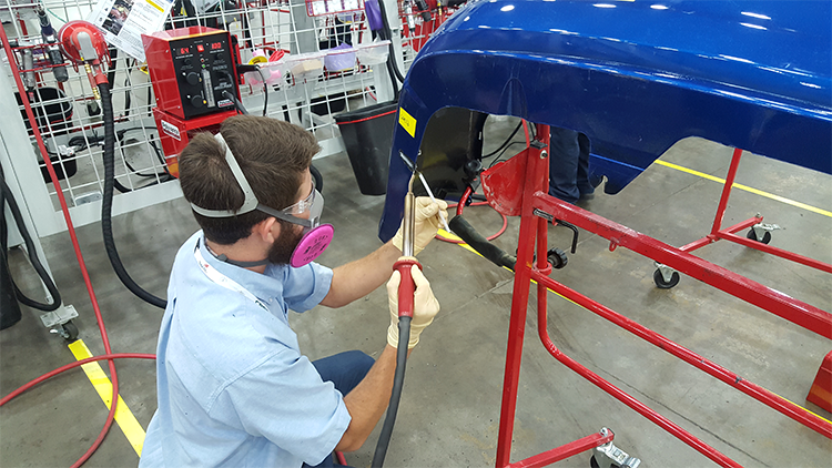 A competitor using the nitrogen plastic welder to make a weld on a bumper.