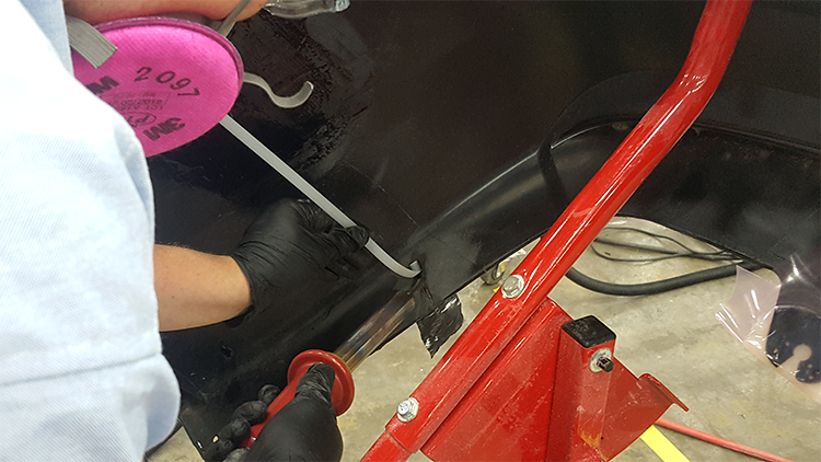 A competitor using the nitrogen plastic welder to make a weld on a bumper.