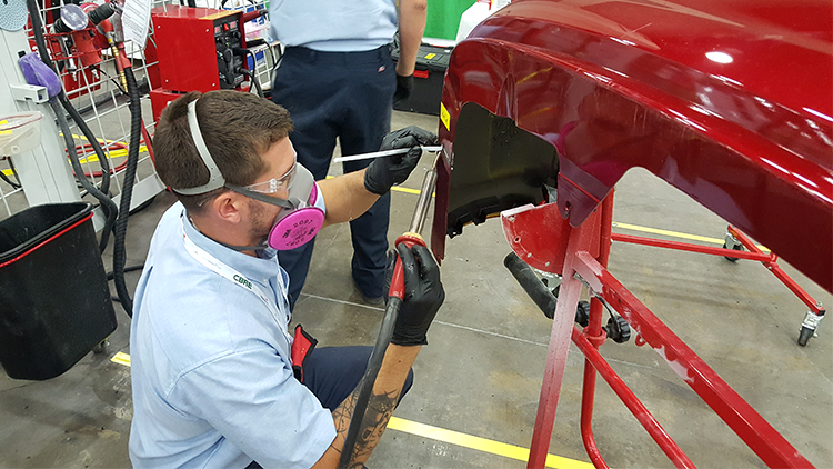 A competitor using the nitrogen plastic welder to make a weld on a bumper.