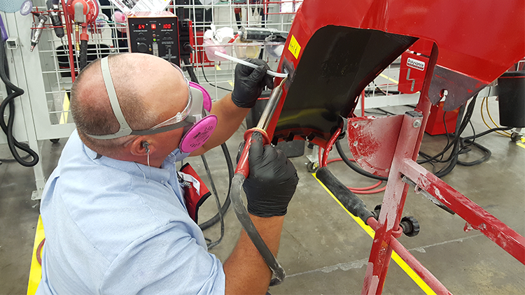 A competitor using the nitrogen plastic welder to make a weld on a bumper.