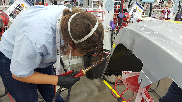 A competitor using the nitrogen plastic welder to make a weld on a bumper.