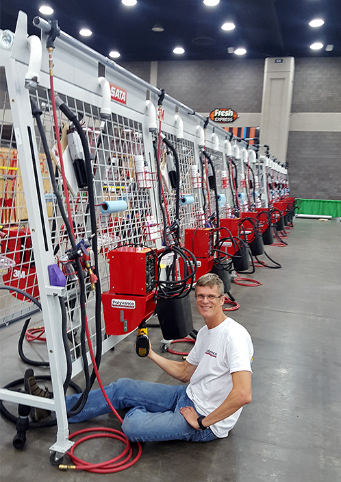 Kurt in front of a 6085 welder with a drill in his hand.