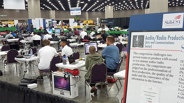 Competitors sitting behind computors.