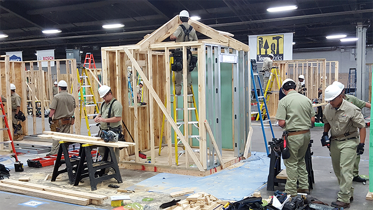 Competitors constructing small buildings.