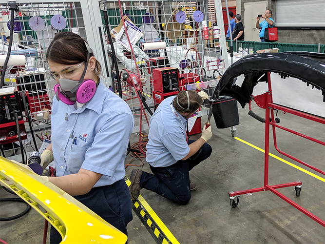 Two competitors repairing plastic bumpers.