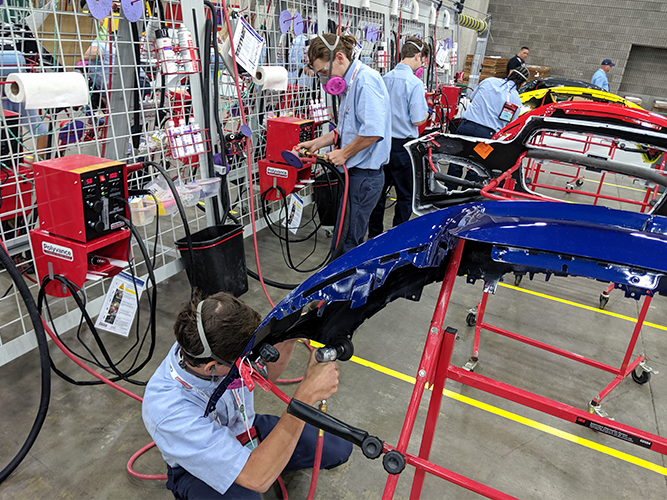 Several competitors repairing bumpers.