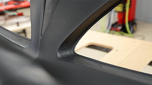 Detail of worn spots on the front bumper after it has been repaired and primed.