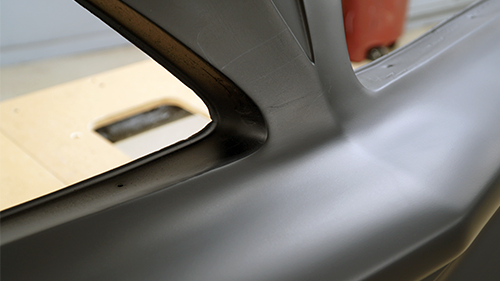 Detail of worn spots on the front bumper after it has been repaired and primed.