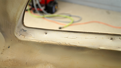 Detail of worn spots on the front bumper after the paint has been sanded off.