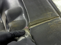 Using a drum sander to sand back the puckered vinyl cover.